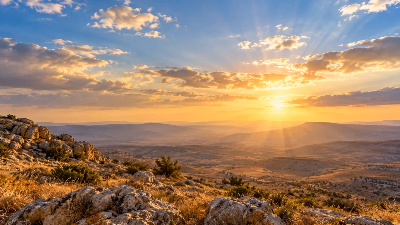 High clouds and ordinary sunlight hang over an empty dry-land valley.
